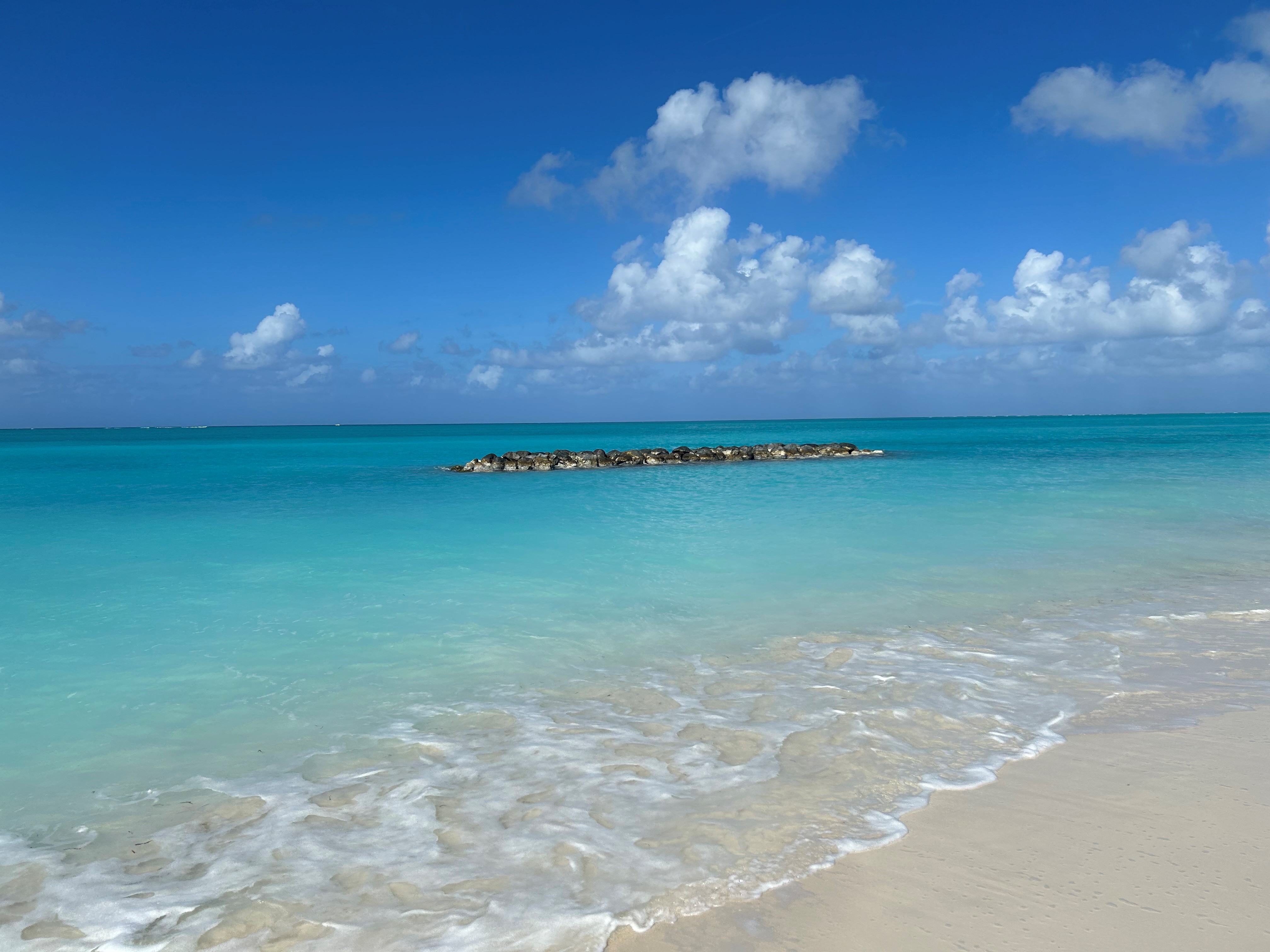 A picture of a beach with rocks in the water